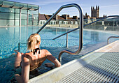 Young woman relaxing in roof top pool, Thermae Bath Spa, Bath, England