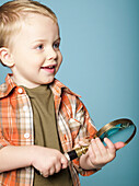 Little boy holding magnifying glass