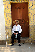 Algeria, Tipaza, man sitting on doorstep