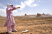 Algeria, region of Tamanrasset, Ahaggar desert, tuareg man pointing at landscape
