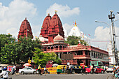 Straßenszene mit rotem Jaintempel im Hintergrund, Old Delhi, Delhi, Indien