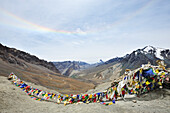 Prayer flags at pass and view to glacier-covered summit, Sirsir La, between Honupatta and Photoksar, Zanskar Range Traverse, Zanskar Range, Zanskar, Ladakh, India
