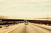 Lone Car on Desert Road, California, USA