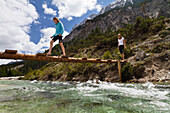 Mädchen balanciert auf Holzsteg über die Isar, Isar-Oberlauf im Hinterautal, Karwendel, Alpen, Tirol, Österreich