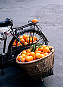 Detail of oranges in baskets on back of bicycle, Chengdu, Sichuan, China