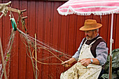 Fisherman repairing his nets Ringkobing, situated right by the inlet Ringkobing Fjord, West Jutland Denmark