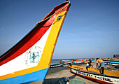 Colourful fishing boats on beach with fisherman in background, Tamil Nadu, India