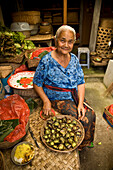 Oldwoman peeling vegetables, Ubud, Bali, Indonesia