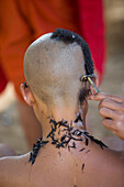 Novice monks having their heads shaved at Wat Naluang, Luang Prabang, Laos.