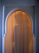 Shadow of woman through arched doorway in the Riad Dar Zelije, Marrakesh, Morocco