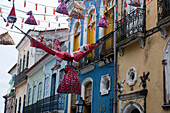 Weihnachtsdekoration mal anders, Ein Weihnachtsmann in einer zwischen Häusern anfgehangenen Hängematte in der Pelourinho Altstadt, Salvador da Bahia, Bahia, Brasilien, Südamerika