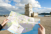 Tourist watching map in front of Belem Tower, Belem, Portugal
