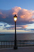 Street lamp with cloud above and sea behind, Costa del Sol, Marbella, Andalucia, Spain