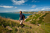 Walker going up stairs up to St Aldhelm's Head on the South West Coastal Path, Purbeck, Dorset, UK.