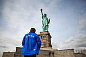 Man standing in front of Statue of Liberty, Liberty Island, New York. USA.
