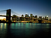 Looking across the East River and the Brooklyn Bridge to the Financial District at dusk, New York, USA