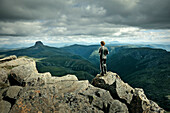 Hiker atop Cradle Mountain, view at Barn Bluff, Cradle Mountain Lake St Clair National Park, Tasmania, Australia