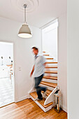 Mann läuft die Treppe runter, Haus eingerichtet im Country-Stil, Hamburg, Deutschland
