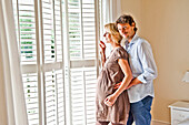 Schwangere Frau und junger Mann schauen aus dem Fenster, Hamburg, Deutschland