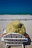 Sitting in a beach chair. Gasparilla Island Inn and Club Swimming pool and beach, USA