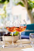 France, Provence, Var, Bandol AOC, pouring a glass of rosé, village ´la Cadière d´Azur´, main square, glasses of rosé at the table of a restaurant