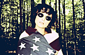 Young Woman Wearing Sunglasses and Wrapped in American Flag