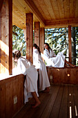 Mother and daughters wearing bathrobes on balcony of a nature hotel, Am Hochpillberg, Schwaz, Tyrol, Austria