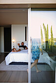 Man lying on a hotel bed, Ramatuelle, Provence-Alpes-Cote d'Azur, France