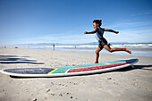 Kind mit Surfboard am Strand, Muizenberg, Peninsula, Kapstadt, Südafrika, Afrika