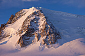 Skitour-Spuren und Bergsteiger unter Mont Blanc du Tacul im Morgenlicht, Chamonix, Mont-Blanc, Frankreich