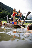 Kinder auf einem Floß im Badesee, Hotel Feuerstein, Gossensaß, Brenner, Südtirol, Trentino-Südtirol, Italien