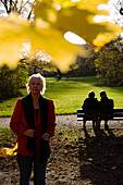 Rentnerin geniesst einen Herbsttag in den Isarauen, München, Oberbayern, Bayern, Deutschland, Europa