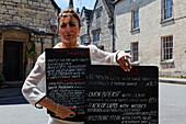 Woman showing the menu of the The Royal Oak Pub, Painswick, Gloucestershire, Cotswolds, England, Great Britain, Europe