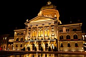 Water fountains in Bundesplatz Confederation Plaza with the Parliament Building Federal Palace of Switzerland in background at night, Bern, Canton Bern, Switzerland