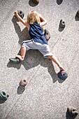 A young boy free climbing on a practice wall