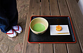 Japanese green tea and a seasonal sweet are served on a laquerware tray at the Fukiage Teahouse inside Rikugien Garden (Six Poem Garden) in the old Komagome District of Tokyo, Japan.