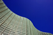 Exterior architectural curves undulate against a clear blue sky at the National Art Center Tokyo, designed by architect Kisho Kurokawa with the largest exhibition space in Japan, and located in the upscale Roppongi District of Tokyo.