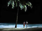 Ein junges Paar am Strand in Boracay in der Nacht, Boracay, Insel Panay, Visayas, Philippinen