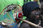 Eine Frau mit Gesichtsbemalung bringt Gabe, Ati Athan Festival, Ibajay, Provinz Aklan, Insel Panay, Visayas, Philippinen