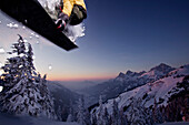 Snowboardfahrer im Sprung vor Bergpanorama, Hahnenkamm, Tirol, Österreich, Europa