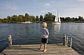 Kind beim Angeln auf einem Steg, Blick auf die Fähre von Missunde, Schlei, Schleswig-Holstein, Deutschland, Europa