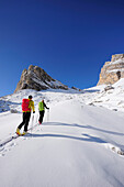 Young woman and young man ascending with crosscountry skis to Corno d'Angolo, Corno d'Angolo, Cortina, Veneto, Dolomites, Italy, Europe