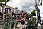 Bus and shoppers on Pembridge Road, Notting Hill, London, England