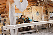 Junges Paar vor einer Berghütte, Idealhang, Brauneck, Tölzer Land, Bayern, Deutschland, Europa