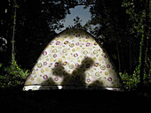 Couple sitting in tent, silhouette view