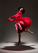 Woman in Red dress dancing under light