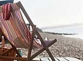 Empty deck chair by beach