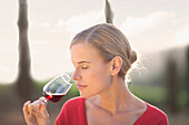 Woman enjoying a glass of red wine. Vineyard, wine