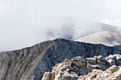 One of Olympus mountain peaks with people on the top of it shoot on a cloudy day, Olympus Mountain, Pieria, Macedonia, Greece