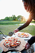 Frau schneidet Pizza, Haus Strauss, Bauernkate in Klein Thurow, Roggendorf, Mecklenburg-Vorpommern, Deutschland